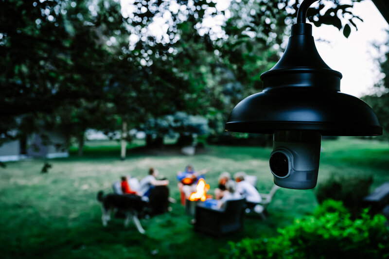 LightCam camera watching over a family gathered around a backyard fire
